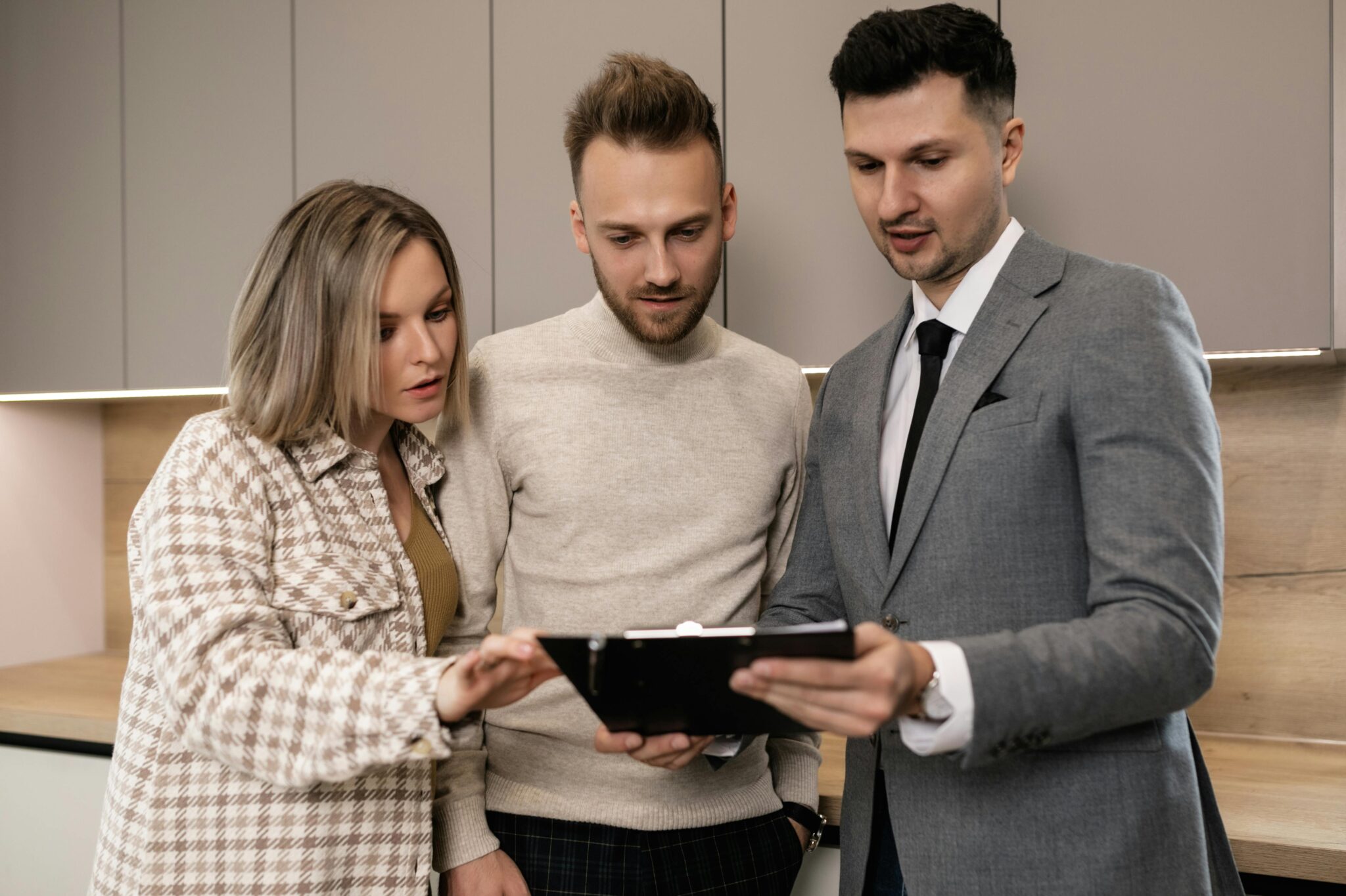 Real estate agent discussing property details with clients indoors.