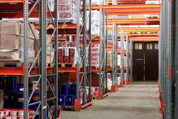 Industrial warehouse interior with organized shelves stacked with packages and goods.